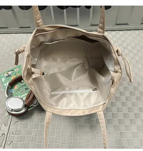 Vista interna della borsa tote in nylon beige con scomparti multipli e tasca con cerniera