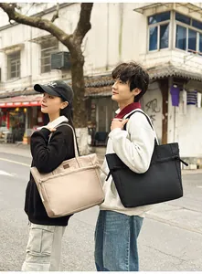 Dettaglio della borsa tote in nylon con decoro a nodo e manici in beige e nero