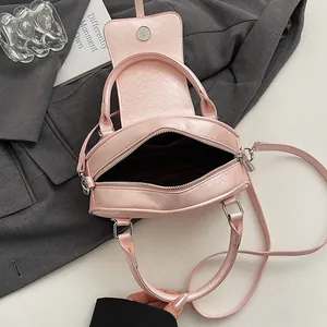 Pink faux leather Boston pillow bag with double handles and adjustable crossbody strap