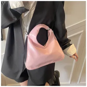 Detail of pink patent leather handbag with silver ball clasp and round handle