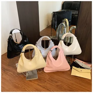Close-up of minimalist triangle handbags with glossy finish and decorative metal spheres