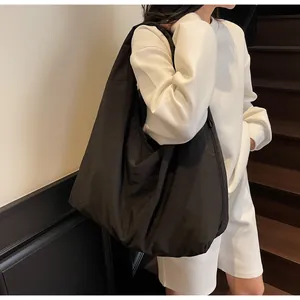 Spacious black canvas tote bag shown on model with casual urban style for commuting