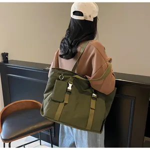 Close-up of army green large tote bag with buckle straps and matching small pouch