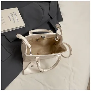 Vue intérieure du sac carré en cuir PU crème montrant la doublure et la poche