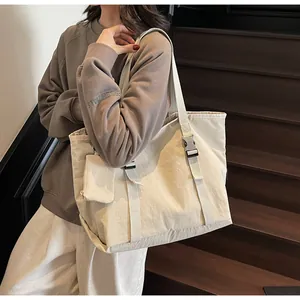 Detail of off-white large capacity tote bag with matching mini zip pouch on side