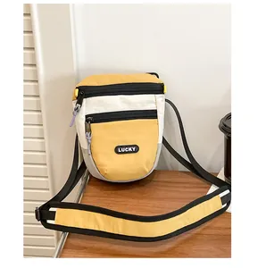 Detailansicht der gelben Crossbody-Tasche mit Lucky-Tag und gepolstertem Schultergurt