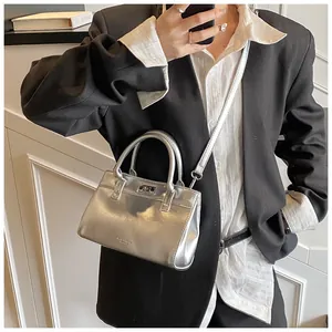 Détail du mini sac argenté métallisé montrant la texture polie et la bandoulière