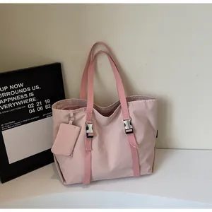Detail of pink canvas tote bag with adjustable silver buckles and a small matching pouch