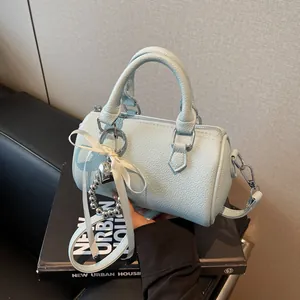 Sac Boston bleu clair avec texture litchi, pendentif coeur et bandoulière amovible