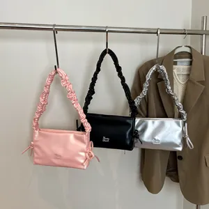 Tre borse a spalla eleganti in rosa, nero e argento con tracolle arricciate e dettagli nodo