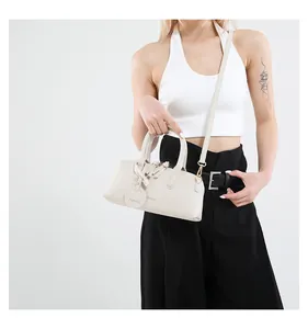 Chic cream leather boston bag styled with a white vest and black trousers for daily commute