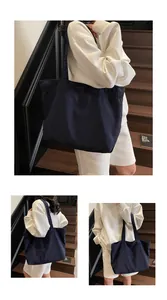 Dreiteilige Ansicht einer großen dunkelblauen Canvas-Tasche kombiniert mit weißer Kleidung