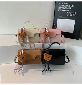 Detailed view of four colorful mini square bags with woven texture and cute bear charms
