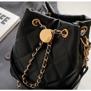 Detailed view of black quilted bucket bag with gold chain strap and leather texture
