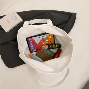 Vista superior de bolso tote grande de lona blanca con interior espacioso para el diario