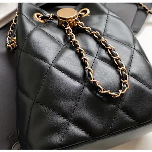 Detail of black quilted leather bucket bag with gold-tone chain and fine stitching