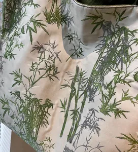 Detail view of smooth off-white tote bag fabric with green and gray bamboo pattern