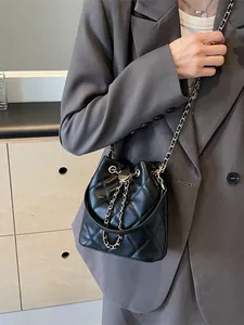 Elegant black quilted bucket bag with gold chain strap and drawstring closure for women