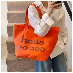 Detail van een feloranje canvas draagtas met artistieke hello-letterbedrukking