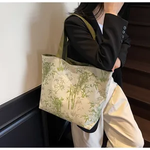 Detail of large canvas tote bag featuring green bamboo prints and army green handles