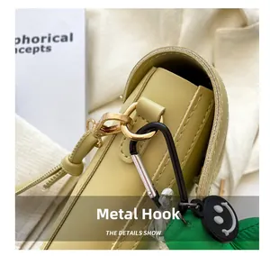 Detailed close-up of premium gold hardware hook and leather strap on yellow crossbody bag