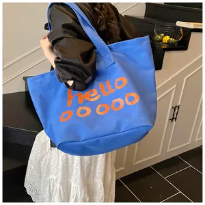Blauwe canvas shopper met oranje tekst toont de pasvorm en de grote capaciteit aan