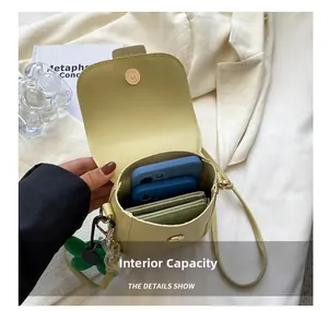 Internal capacity of the pale yellow mini crossbody bag showing space for phones and wallet