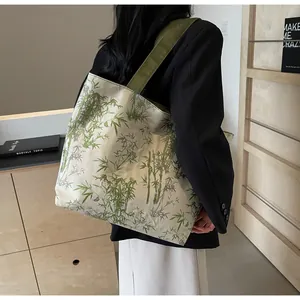 Detail of bamboo print tote bag showing large capacity and green woven shoulder strap