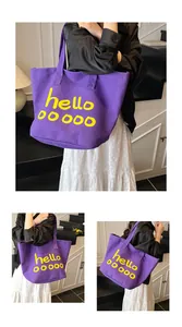 Detailweergaven van de paarse canvas draagtas met gele hello-tekst en vijf cirkels