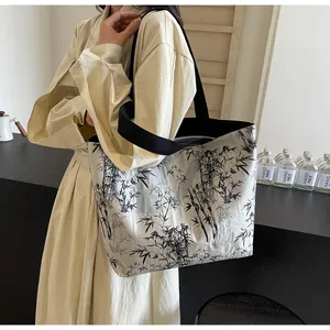 Detail of canvas tote bag featuring ink wash bamboo print and black wide shoulder strap