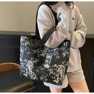 Detail of large tote bag featuring artistic bamboo leaf print and sturdy shoulder straps