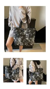 Detail of large black tote bag with white bamboo leaf print and wide shoulder straps