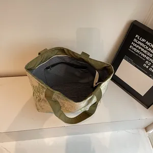 Large canvas tote bag with green bamboo leaf print and striped lining for daily use