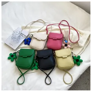 Detail showing five mini crossbody phone bags in PU leather with floral charm decorations