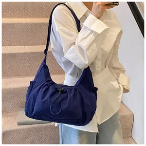 Detail van de marineblauwe canvas crossbodytas met trekkoordzak en verstelbare riem