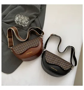 Detail view of vintage saddle bags in brown and black with printed flaps and wide straps