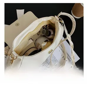 Vue intérieure du sac beige plissé montrant le compartiment principal et la poche zippée