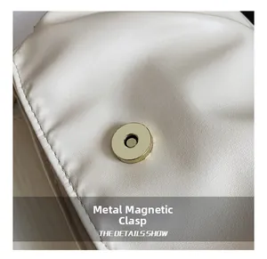 Détail d'un sac beige plissé montrant le fermoir magnétique doré et le grain du cuir