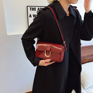 Sac à bandoulière vintage en cuir verni bordeaux avec boucle fer à cheval dorée