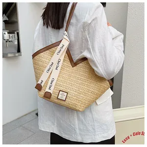Detail of woven straw tote bag with brown leather trim and sport fashion patch