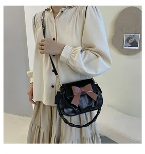 Détail du sac en cuir PU noir avec nœud marron et poignée tressée élégante pour femmes