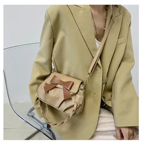 Détail du sac bandoulière plissé en PU beige avec nœud marron et poignée tressée chic