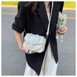 Detail of white PU crossbody bag with large organza bow and pearl handle ornament