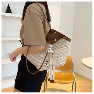 Detail of straw bucket bag with dark brown leather trim and chic printed ribbon