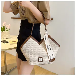 Detail of hand-woven tote bag featuring brown leather trim and chic decorative ribbon strap
