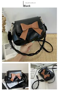 Détail du sac à bandoulière noir avec grand nœud marron et bandoulière torsadée