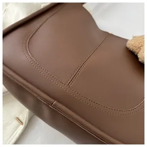 Detail showing high-quality dual stitching and matte brown faux leather texture of the tote bag