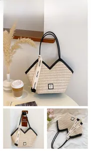 Detail of woven straw tote bag featuring black leather trim and lettered ribbon detail