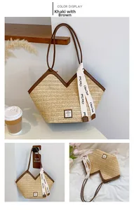 Detailed close-up of woven straw tote bag with brown leather trim and silk ribbon