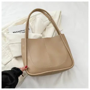 Close-up of khaki PU leather tote bag with U-shaped stitching and smooth matte texture